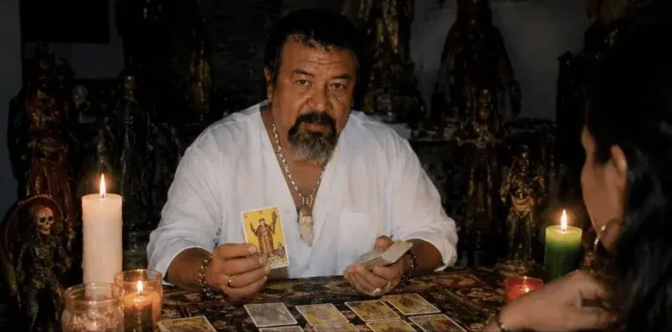 Vidente mostrando una carta entre velas