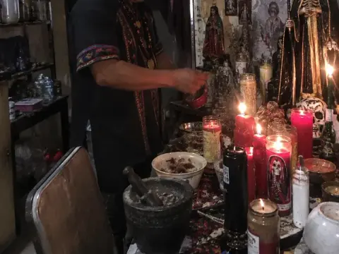 Veladoras encendidas ante la Santa Muerte